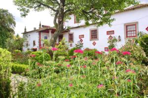 布拉加Quinta da Maínha - Charming Houses的白色房子前面的花园,花粉红色