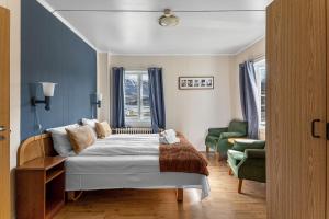 于尔维克Hardanger Guesthouse的卧室配有床、椅子和窗户。