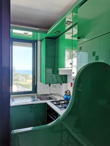 比谢列Il Gabbiano casa al mare的绿色的厨房设有水槽和窗户