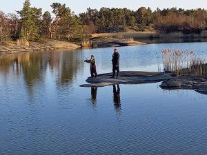 弗格罗Sommarö Stugor的两个人站在岛上的水域里