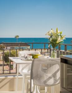 EsteponaSunny modern Apartment Perfect located的阳台上配有白色的桌椅,享有海景