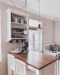 哈普萨卢Linnuse Apartement的厨房配有木桌和白色椅子