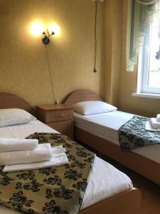 卡巴丁卡Связь Времён Гостевой Дом的酒店客房设有两张床和窗户。