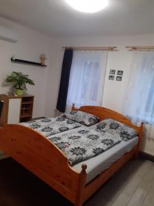 沙罗什保陶克Oázis Apartman的一间卧室配有一张带黑白色棉被的木床。