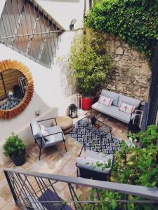 阿维尼翁La Maison Grivolas Appartements et Maison d'hôtes的天井配有沙发、椅子和植物