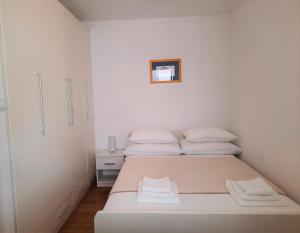 巴尔巴里加Apartment Mato的一间白色卧室,配有两张床和橱柜