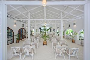 南马累环礁艾布度乡村度假村的大楼内一间设有白色椅子和桌子的房间