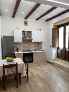 锡拉库扎Appartamenti Vittoria的厨房配有白色橱柜和桌椅