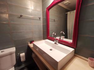 科孚镇Puppet Guesthouse的浴室设有白色水槽和红色镜子
