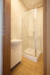 罗兹Royal Aparthotel Piotrkowska 33的带淋浴、盥洗盆和卫生间的浴室