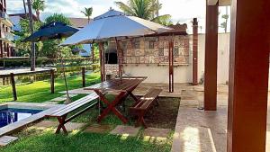 泰巴Casa Taíba Beach Resort的野餐桌和带雨伞的长凳