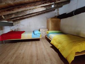 拉弗雷斯内达Loft Apartamento Rural La Fresneda - Casa Vidal的铺有木地板的客房内的两张床
