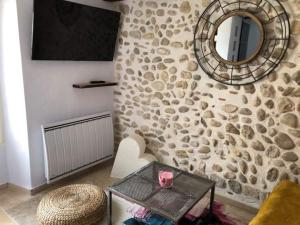 RoumoulesEntre lac et lavandes的客厅设有一面带镜子的石墙