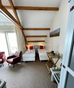奥德斯希尔德Havenhotel At Sea Texel的一间设有两张床和一张桌子及椅子的房间