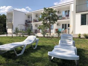 科布列韦Ассоль的两把白色椅子坐在建筑物前面的草上