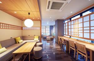 京都THE POCKET HOTEL Kyoto Karasuma Gojo的餐厅设有桌椅和窗户。