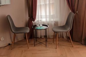 米尔哥罗德Espresso的两把椅子和一张桌子,上面有花瓶