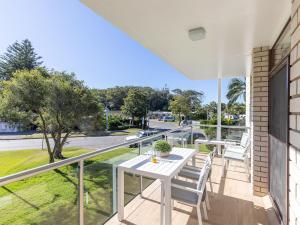 尼尔森湾Villa Ellisa 4 beautiful unit with beautiful water views at Little Beach的阳台配有白色的桌椅。
