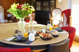 布鲁瓦DEMEURE DES CORDELIERS avec parking privé的一张带早餐食品和花瓶的桌子