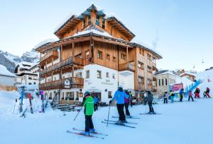 阿拉巴Hotel Mesdi的一群滑雪者在滑雪小屋前滑雪