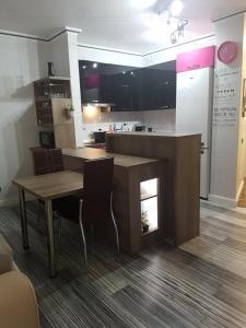 克卢日-纳波卡Central luxury apartment in Platinia Residence的厨房配有桌子和带椅子的柜台。