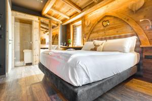 福尔加里亚John Luxury Suites的一间卧室设有一张带木制天花板的大床