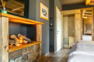 福尔加里亚John Luxury Suites的卧室内带石头壁炉的房间