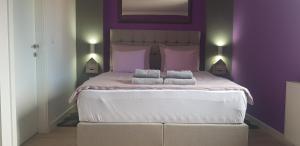 萨格勒布Apartment Mavero-Free Private Parking的紫色卧室配有一张大床和两个枕头