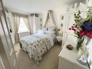 利明顿Beautiful Lymington New Forest Getaway的一间白色的卧室,配有一张床和花瓶