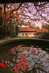 科钦Chittoor Kottaram Royal Mansion- CGH Earth的一座房子前面的红花池