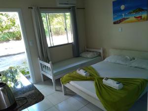 邦比尼亚斯Pousada Camping Bombinhas的一间卧室设有两张床、一个窗口和一个长凳