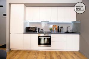 阿特劳Avangard Aparts - Sun Town的厨房配有白色橱柜和炉灶。