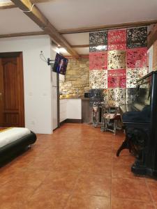 希洪Apartamento turístico Somió的一间设有钢琴和石墙的房间