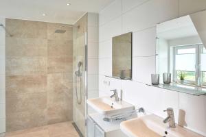 洛布Meeresvilla Lobbe的白色的浴室设有2个盥洗盆和淋浴。