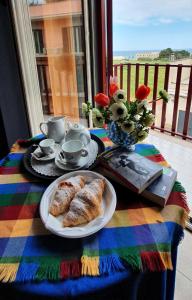 焦维纳佐Hotel mediterraneo的一张桌子,上面放着一盘糕点和一本书