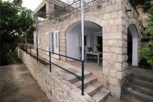 斯拉诺Holiday Home Odiseja的一座带楼梯的石头建筑,入口处
