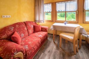 贝希特斯加登Pension Villa Lockstein的客厅配有红色的沙发和桌子