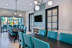 坦帕Hyatt House Tampa Airport/Westshore的一间带桌子和蓝色椅子的用餐室