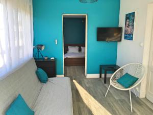 滨海圣帕莱Vacances Sur Mer的蓝色客房 - 带床和椅子