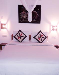 埃拉Ella Secret Paradise的卧室配有白色的床和2个枕头