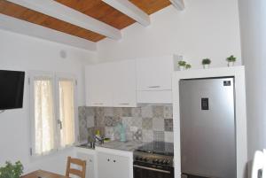阿格里真托LE DIMORE DI DAMAROPE'的厨房配有白色橱柜和不锈钢冰箱