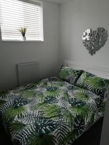 梅瑟蒂德菲尔The Antelope Hotel的一间卧室配有一张带绿色和白色棉被的床