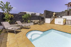 普拉亚布兰卡Villa Azure - LH122 By Villas Now Ltd的庭院内的游泳池,配有椅子和庭院