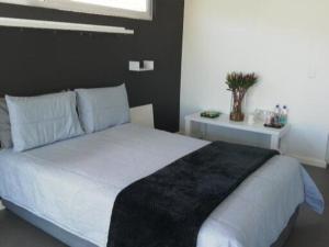 克尼斯纳Knysna Budget Friendly Stay的卧室配有一张带黑色毯子的大型白色床。