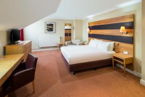 切斯特QMH切斯特假日皇冠酒店的配有一张床和一张书桌的酒店客房