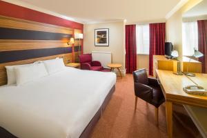 切斯特QMH切斯特假日皇冠酒店的配有一张床和一张书桌的酒店客房