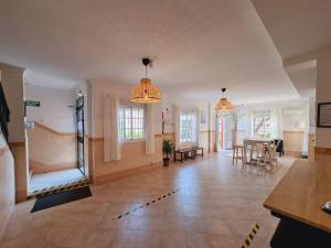 马塔拉斯卡尼亚斯Victoria Hotel的一间带两个吊灯的客厅和一间用餐室