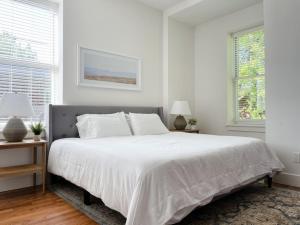 诺克斯维尔Historic 1900s Townhome with a Modern Flair的白色卧室设有一张大床和两个窗户