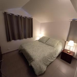 BlaruLa petite campagne的一间卧室配有一张带两盏灯的床和一扇窗户。