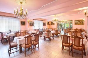 莫雄马扎尔古堡全景酒店的一间带桌椅和吊灯的用餐室